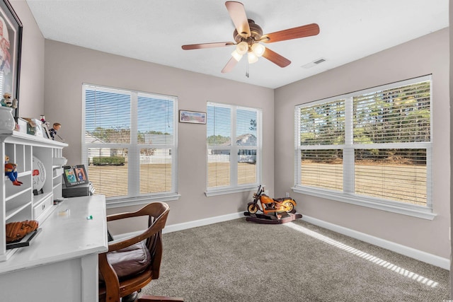 carpeted office space featuring ceiling fan