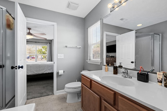 bathroom featuring ceiling fan, a healthy amount of sunlight, vanity, and toilet