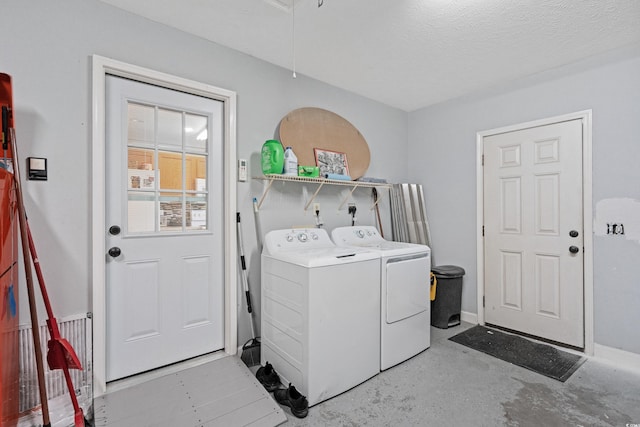 washroom featuring a textured ceiling and washing machine and clothes dryer