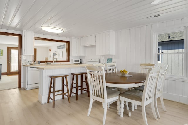 dining room with sink, wood ceiling, and light wood-type flooring