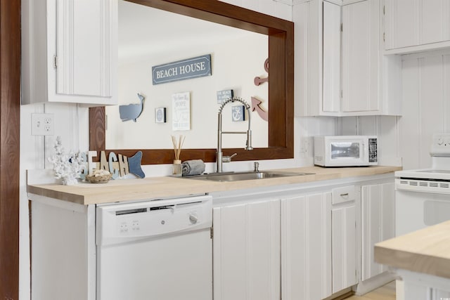 kitchen with white cabinets, sink, and white appliances