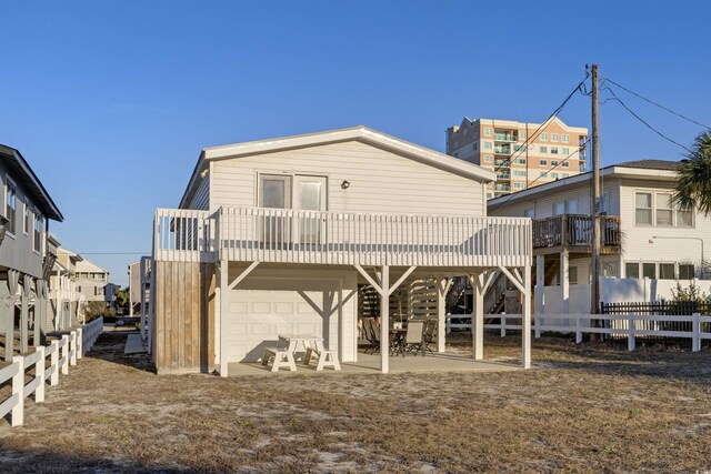 rear view of house featuring a garage and a patio area