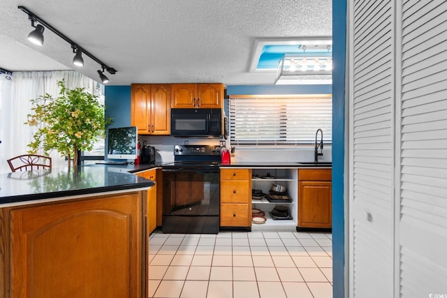 kitchen featuring black appliances, sink, light tile patterned flooring, a textured ceiling, and rail lighting