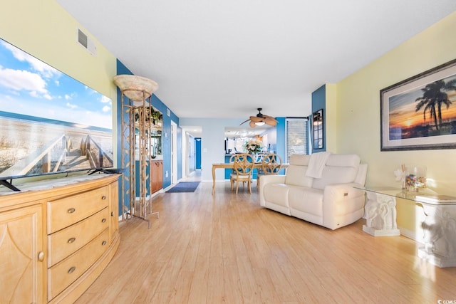 living room with ceiling fan and light hardwood / wood-style flooring