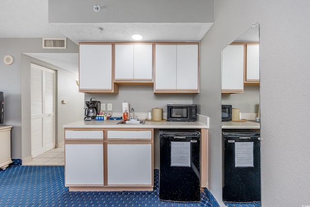 kitchen featuring dishwashing machine, tile patterned flooring, a textured ceiling, white cabinets, and sink