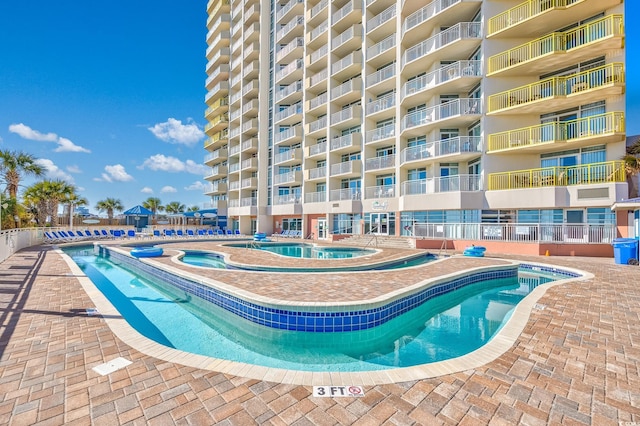 view of pool featuring a hot tub and a patio