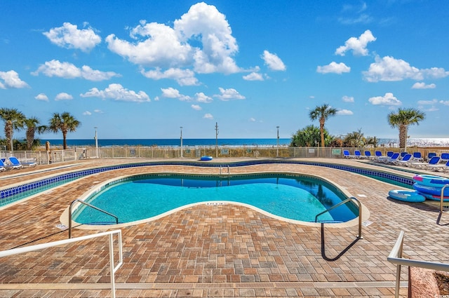 view of swimming pool with a water view and a patio area