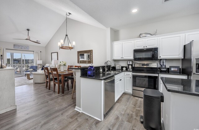 kitchen featuring kitchen peninsula, sink, appliances with stainless steel finishes, white cabinets, and ceiling fan with notable chandelier