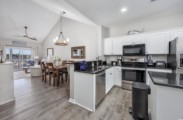 4210 Coquina Harbour Dr Unit A-16, Little River, SC 29566 - kitchen featuring stainless steel appliances, white cabinetry, a peninsula, light wood-type flooring, and high vaulted ceiling