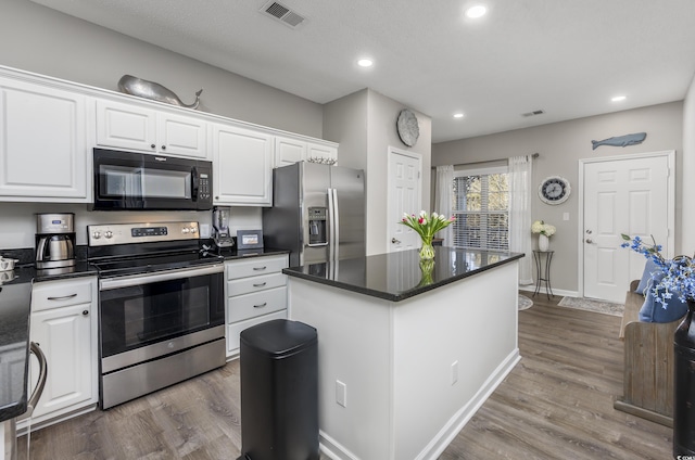 4210 Coquina Harbour Dr Unit A-16, Little River, SC 29566 - kitchen featuring stainless steel appliances, white cabinets, dark countertops, wood finished floors, and recessed lighting