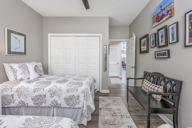 bedroom featuring ceiling fan, a closet, and dark wood-type flooring