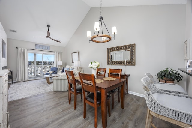 dining area with wood-type flooring, vaulted ceiling, and ceiling fan with notable chandelier