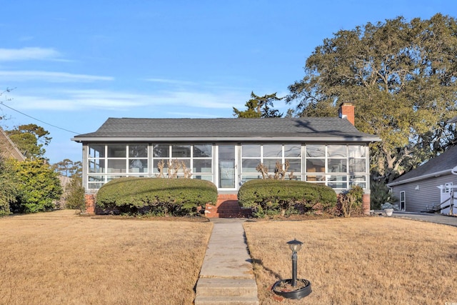 view of front of property with a front lawn and a sunroom