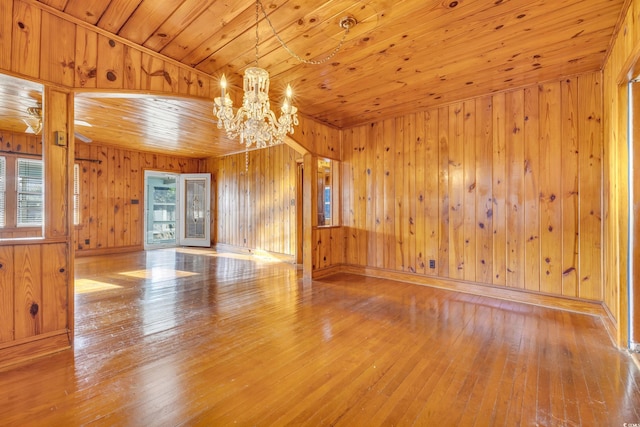 empty room featuring wood-type flooring, plenty of natural light, and wooden ceiling