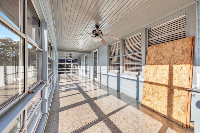 unfurnished sunroom featuring ceiling fan