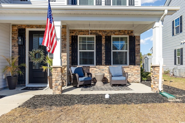 entrance to property featuring a porch and central AC unit