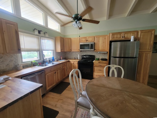 kitchen featuring light hardwood / wood-style floors, stainless steel appliances, decorative backsplash, beam ceiling, and sink