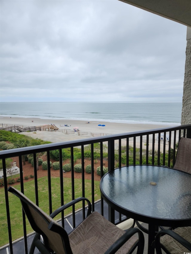 balcony featuring a water view and a beach view