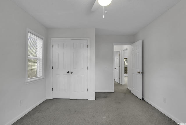 unfurnished bedroom featuring ceiling fan, a closet, and light carpet