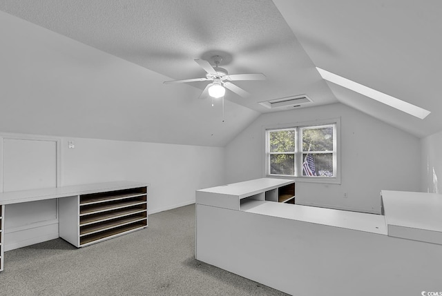 office area featuring a textured ceiling, ceiling fan, and lofted ceiling with skylight