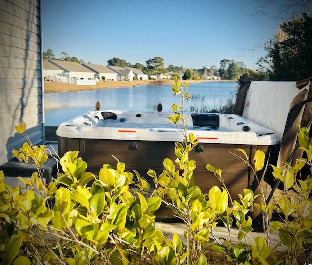 exterior space featuring a water view and a hot tub