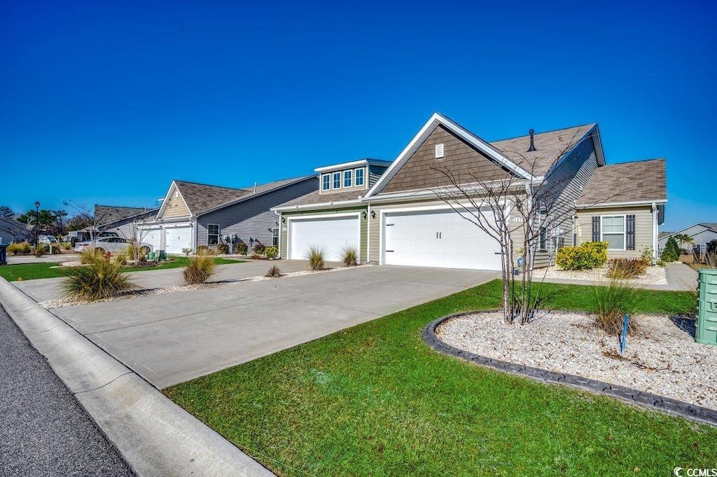 view of front of property featuring a front lawn and a garage