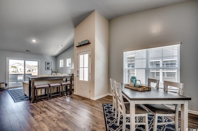 dining space with vaulted ceiling, a wealth of natural light, and hardwood / wood-style floors