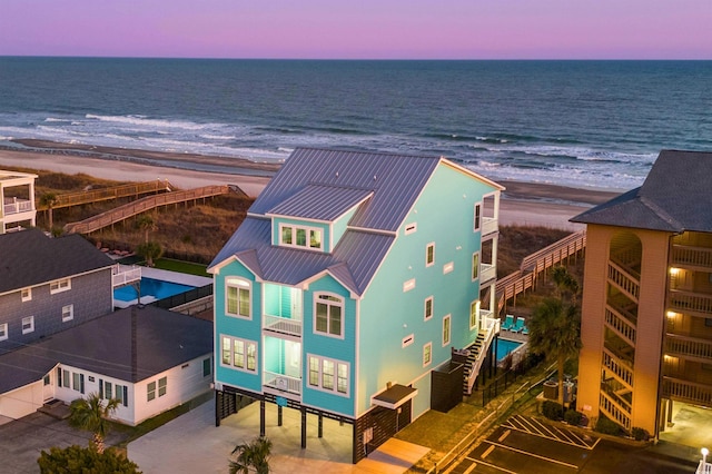 aerial view at dusk with a view of the beach and a water view