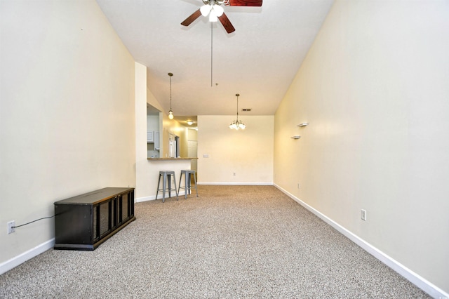 unfurnished living room with ceiling fan, baseboards, and carpet flooring