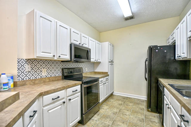 kitchen featuring stainless steel appliances, visible vents, baseboards, white cabinetry, and backsplash