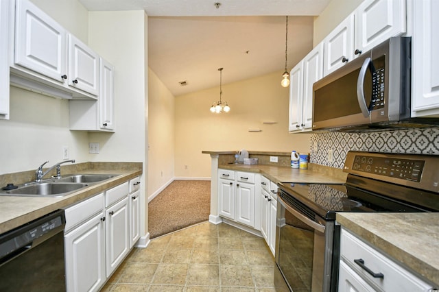 kitchen featuring stainless steel appliances, lofted ceiling, hanging light fixtures, white cabinetry, and a sink