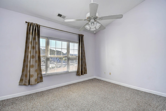 carpeted spare room with a ceiling fan, visible vents, and baseboards