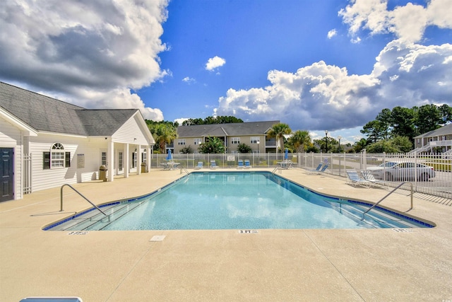 community pool with a patio and fence