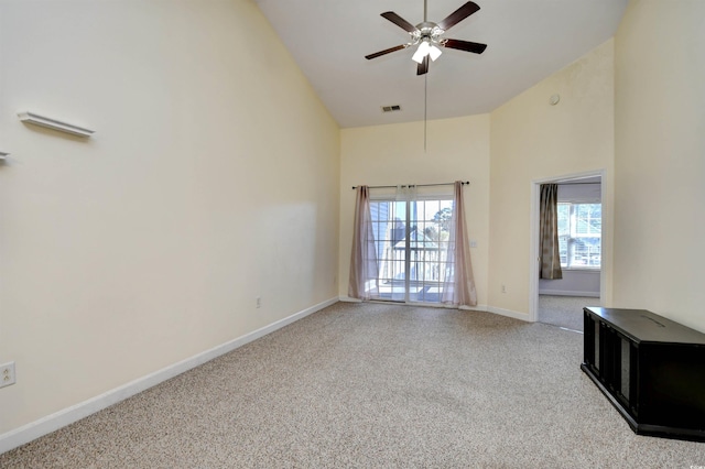 spare room featuring plenty of natural light, visible vents, high vaulted ceiling, and baseboards