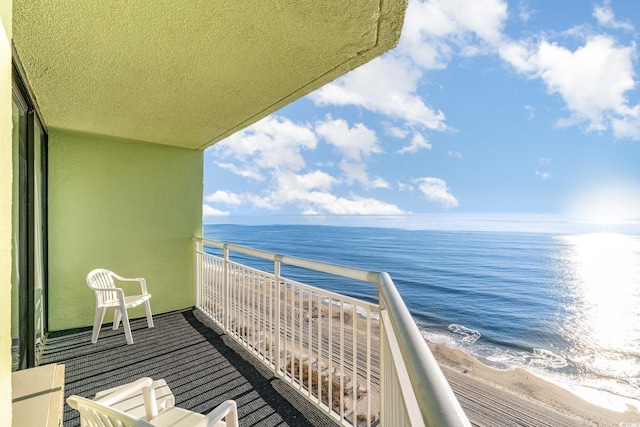 balcony featuring a beach view and a water view