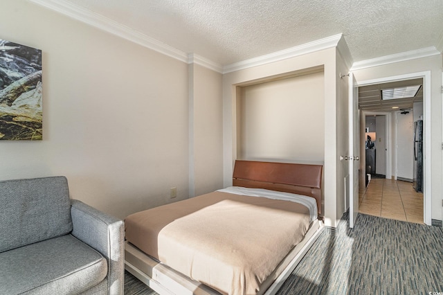 bedroom featuring a closet, stainless steel refrigerator, a textured ceiling, and ornamental molding