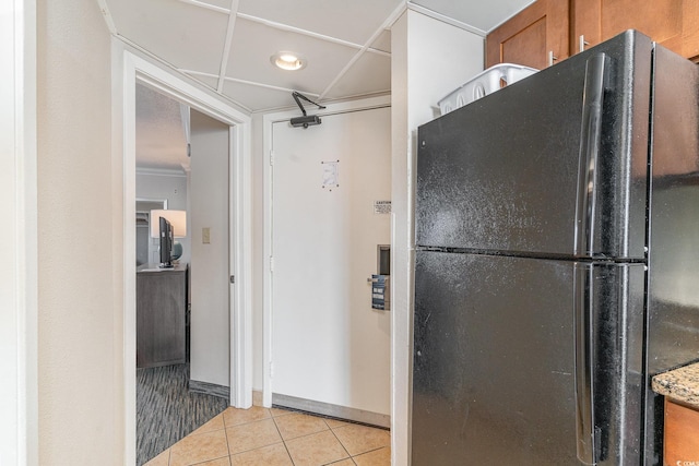 kitchen with light tile patterned floors and black fridge