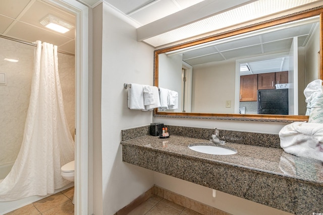 bathroom featuring toilet, tile patterned flooring, and sink