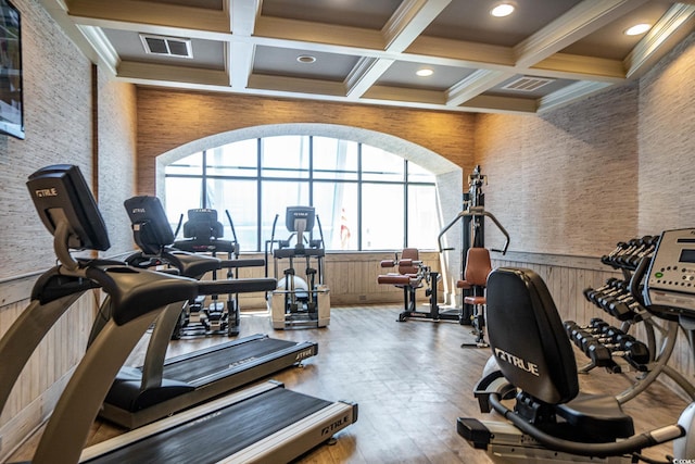 workout area featuring ornamental molding, wood-type flooring, and coffered ceiling