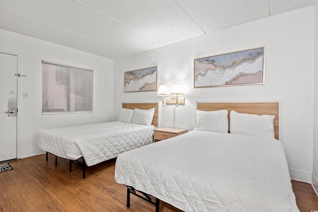 bedroom with baseboards and wood finished floors