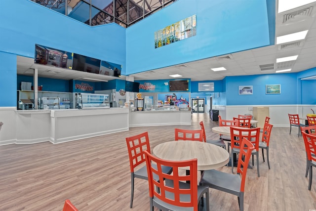 dining area with visible vents, a drop ceiling, and wood finished floors