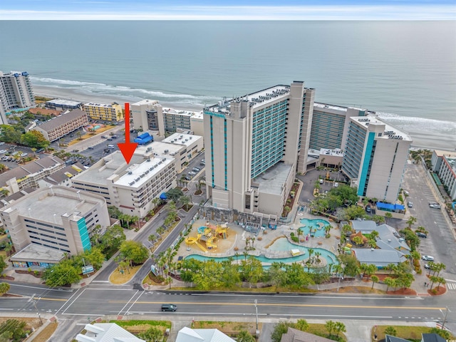 drone / aerial view with a view of city, a water view, and a view of the beach