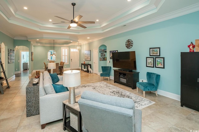 living room with ceiling fan, crown molding, and a raised ceiling