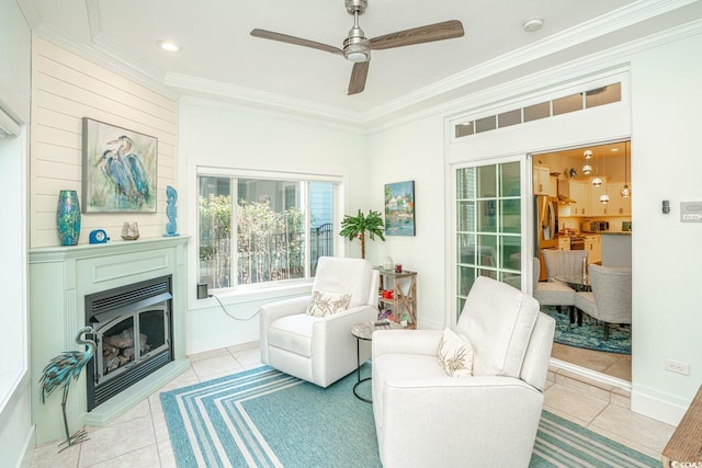 sitting room featuring ceiling fan, light tile patterned floors, and crown molding