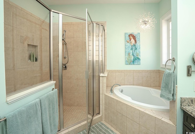 bathroom with separate shower and tub, vanity, and a notable chandelier