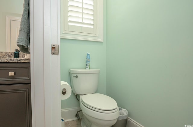 bathroom with toilet, tile patterned flooring, and vanity