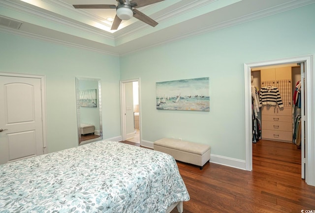 bedroom featuring ceiling fan, ensuite bath, a closet, ornamental molding, and a walk in closet