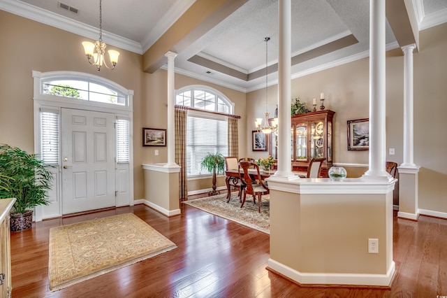 foyer entrance with a healthy amount of sunlight, a tray ceiling, crown molding, and an inviting chandelier