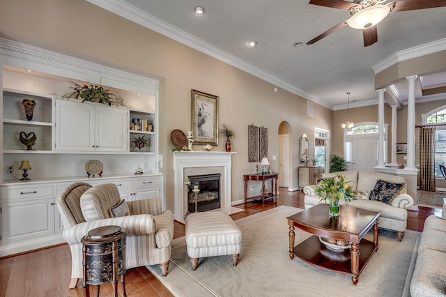 living room with ceiling fan, ornamental molding, ornate columns, and light hardwood / wood-style floors