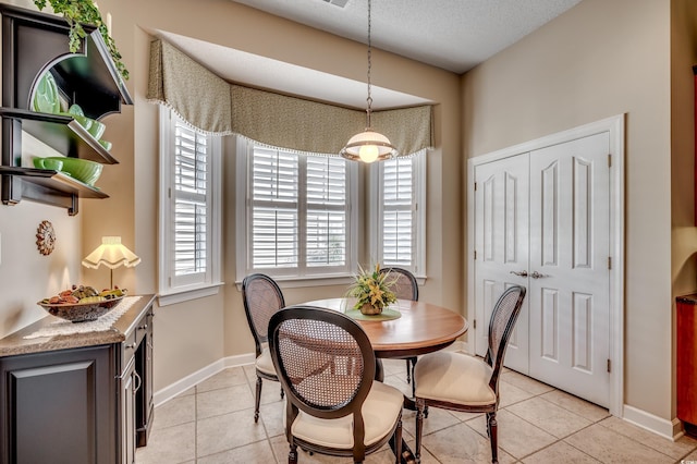 dining space featuring a textured ceiling and light tile patterned flooring